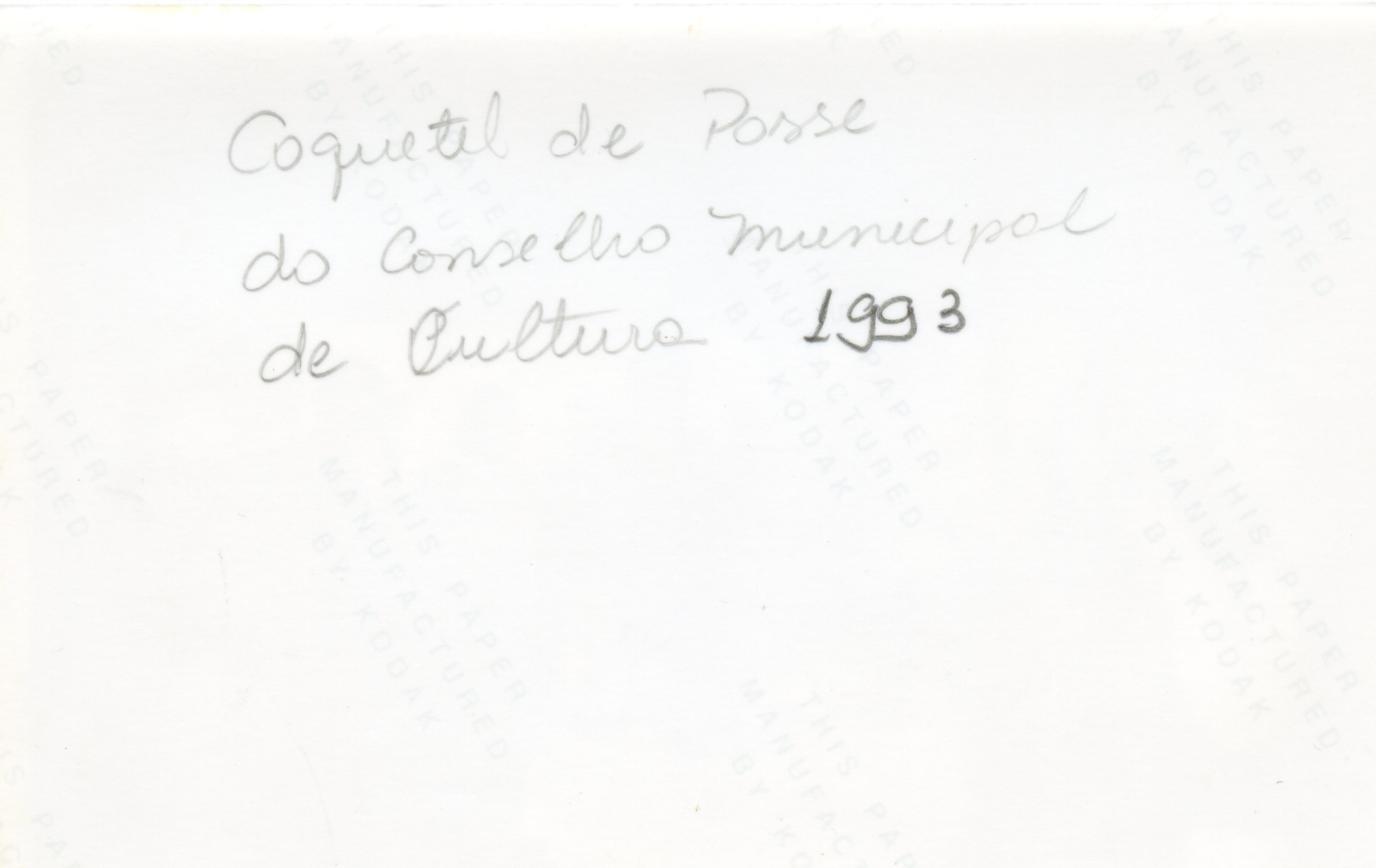 O verso de uma fotografia contendo uma inscrição manuscrita em tinta preta. O texto identifica o evento como o 'Coquetel de Posse do Conselho Municipal de Cultura' ocorrido em 1993, servindo como registro documental de uma atividade cultural local.