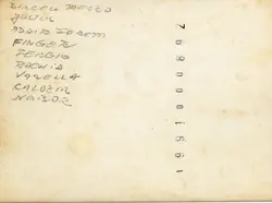 O verso de uma fotografia antiga contendo uma lista de nomes manuscritos e uma numeração de revelação impressa na margem. O papel apresenta sinais de envelhecimento e manchas amareladas típicas de fotografias guardadas por décadas.
