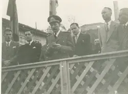 Fotografia em preto e branco retratando um oficial militar discursando em um evento público, possivelmente uma cerimônia oficial em uma pequena cidade brasileira. O grupo de homens ao redor veste trajes formais da época, sugerindo um contexto político ou cívico ocorrido em meados do século XX.