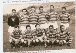 Fotografia em preto e branco de um time de futebol amador posando em um campo de grama, provavelmente em meados do século XX. Os jogadores vestem camisas listradas e calções claros, com anotações manuscritas identificando os nomes dos atletas nas margens superior e inferior.