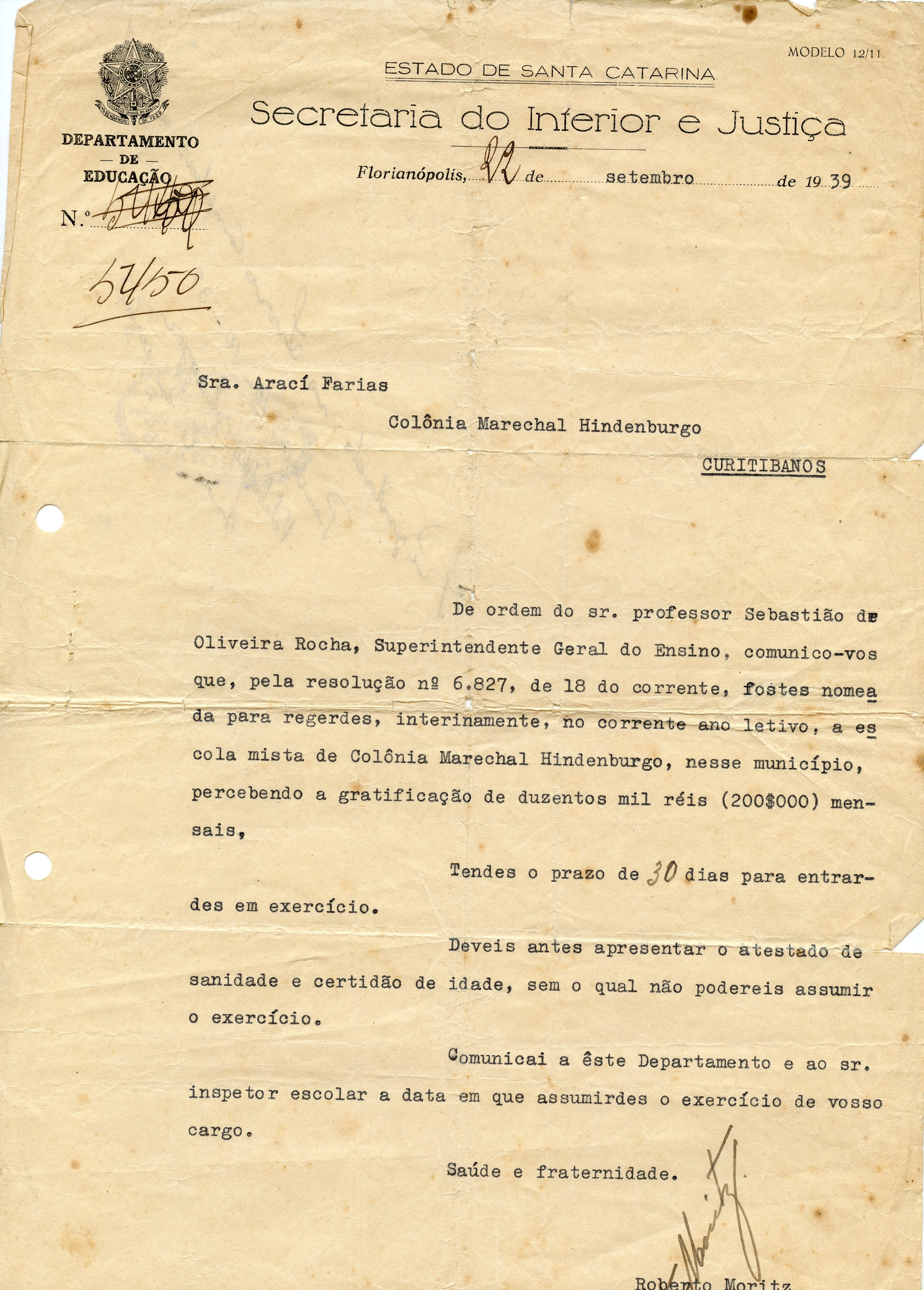 Documento oficial datilografado da Secretaria do Interior e Justiça do Estado de Santa Catarina, datado de 1939. O texto comunica a nomeação de uma professora para uma escola na Colônia Marechal Hindenburgo, em Curitibanos, refletindo a estrutura administrativa educacional da época.